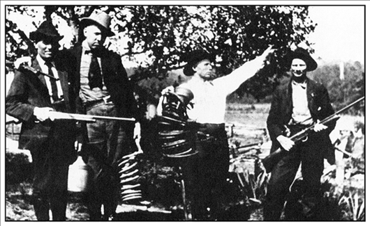 Jasper Roy from Helena and friends display the ruins of a captured whiskey still